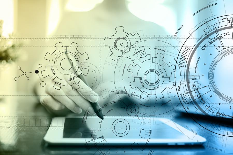 Concept photograph for development engineering.  Image with technology interface, gears, draft, table, man sitting at desk with pointer hovered over tablet.