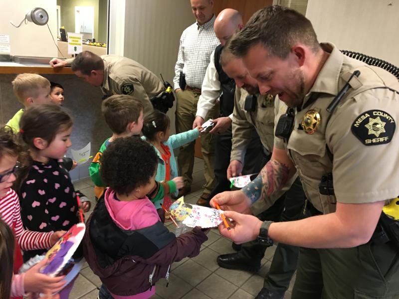 Photograph of of deputies from the Sheriff's Office with a group of young children from New Emerson school