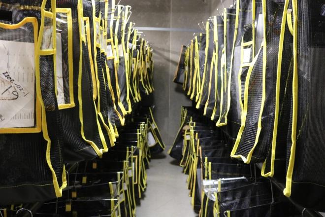 Photograph of the inside of the Inmate Property room with items in bags and tagged with inmate information