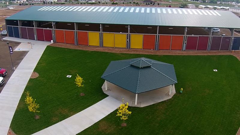 Aerial photograph of Exposition park showing the Gazebo, trees, large grass area, fire hydrant, and sidewalks with the CW Construction Arena in the background