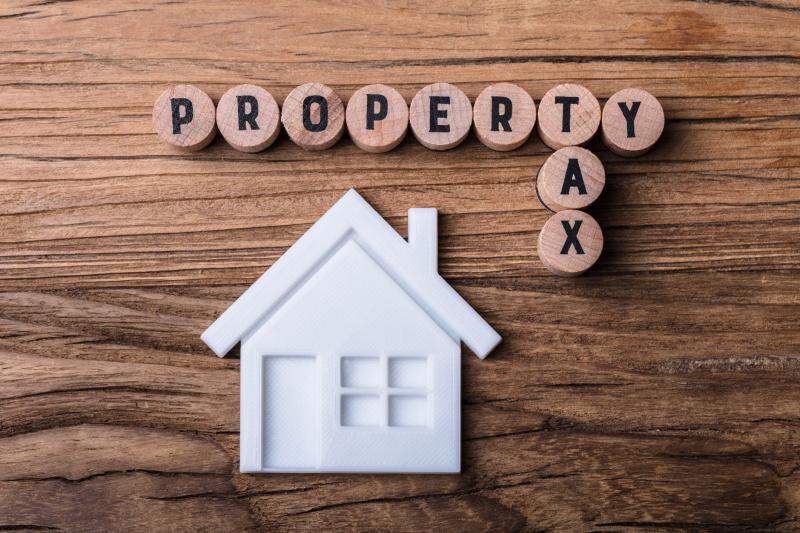 Photograph of desk with round block tiles spelling out Property Tax with a house shape under it