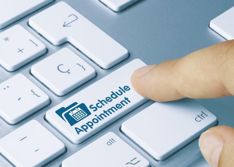 Photograph of computer keyboard with "Schedule Appointment" button with icon for calendar and a file folder behind it