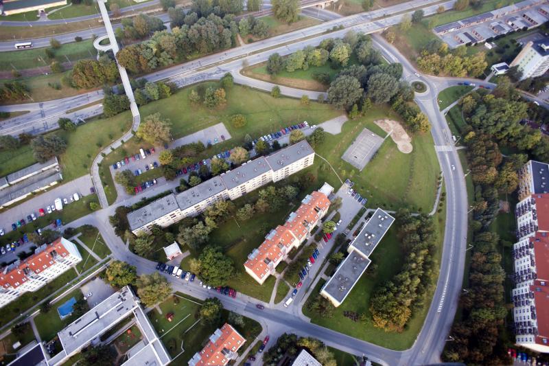 Photograph of aerial city view with crossroads, roads, houses, parks, parking lots, bridges