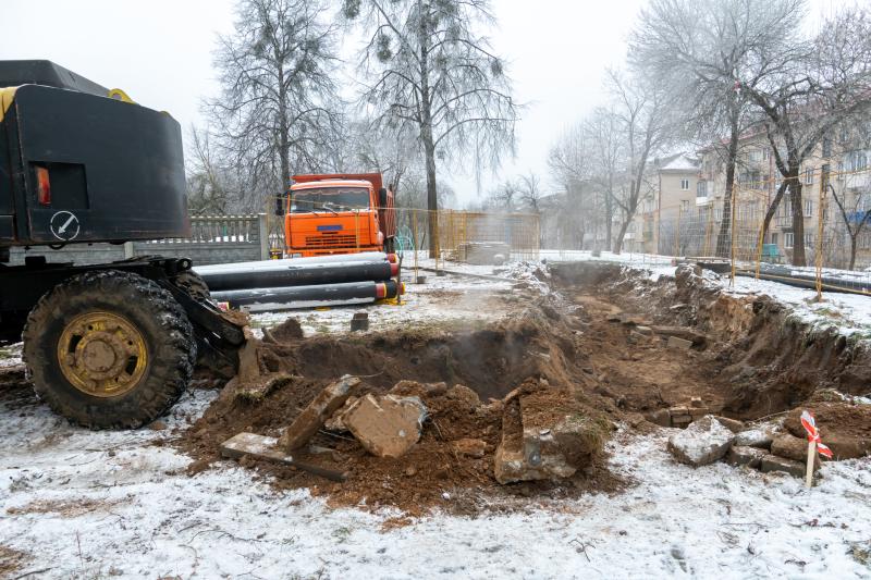 Photograph of Construction Site. Excavator digging holes for laying new pipes