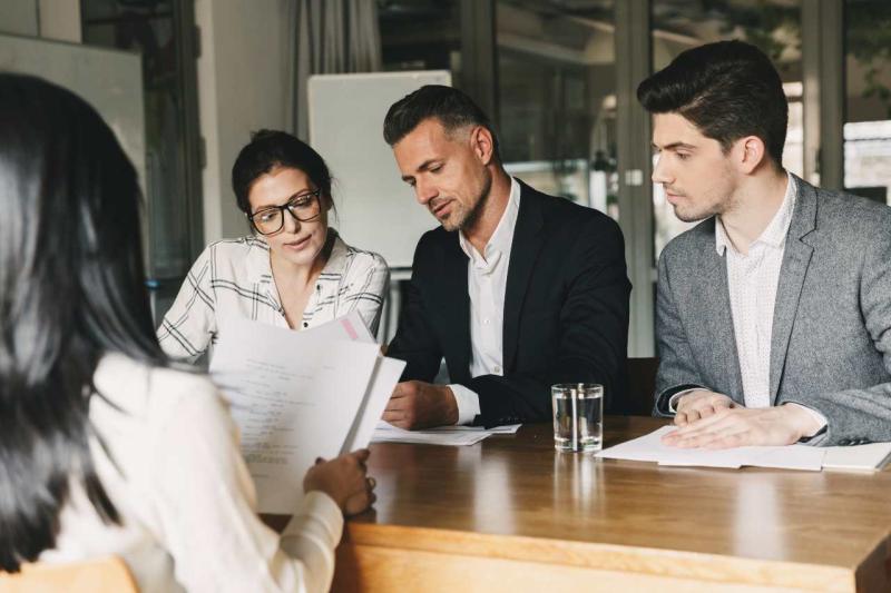 Three workers together reviewing a document