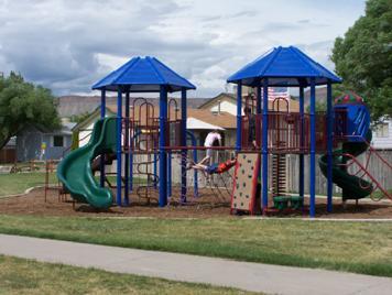 playground equipment in the park with a slide and small climbing wall