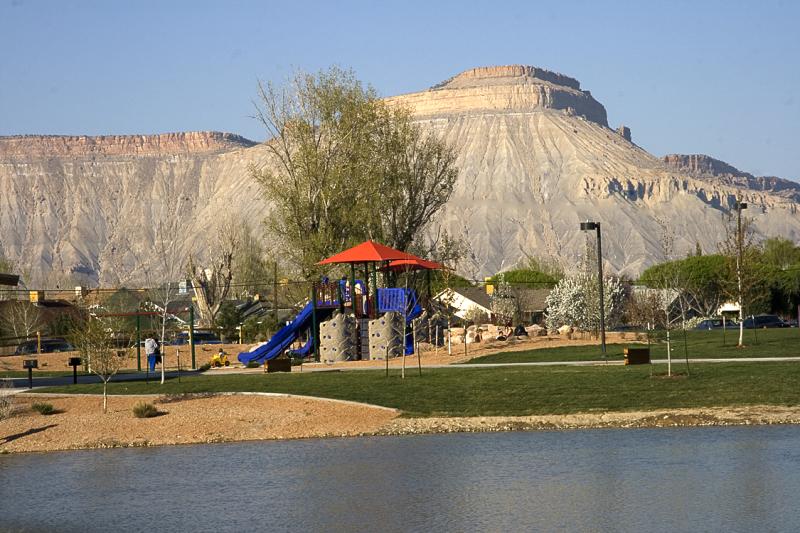 landscape view of the lake in the foreground, playground, and then Mt. Garfield in the distance