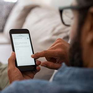 guy scrolling on black cell phone