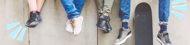 4 teens with lower legs and feet showing plus 1 skateboard