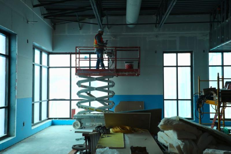 Man working on inside of Clifton Community Campus building. 