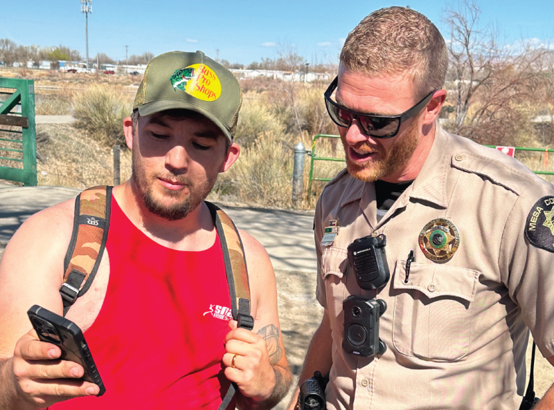 Deputy Nick Bouton stands with a citizen as they discuss the disc golf course opened in January 2024.