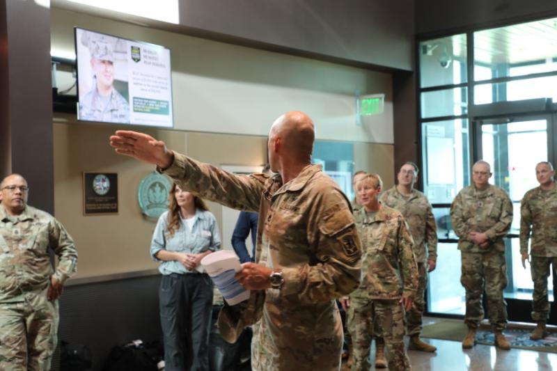 Many Army soldiers standing in a building. 