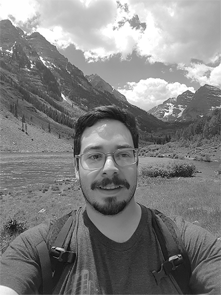 Self photo with mountains, valley and sky in the background.