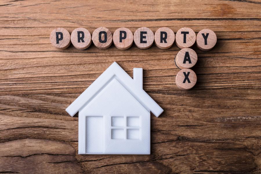 Photograph of desk with round block tiles spelling out Property Tax with a house shape under it