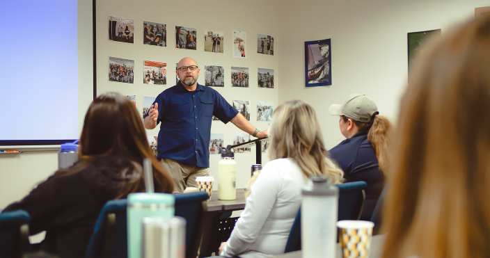 An instructor presents to an attentive crowd 