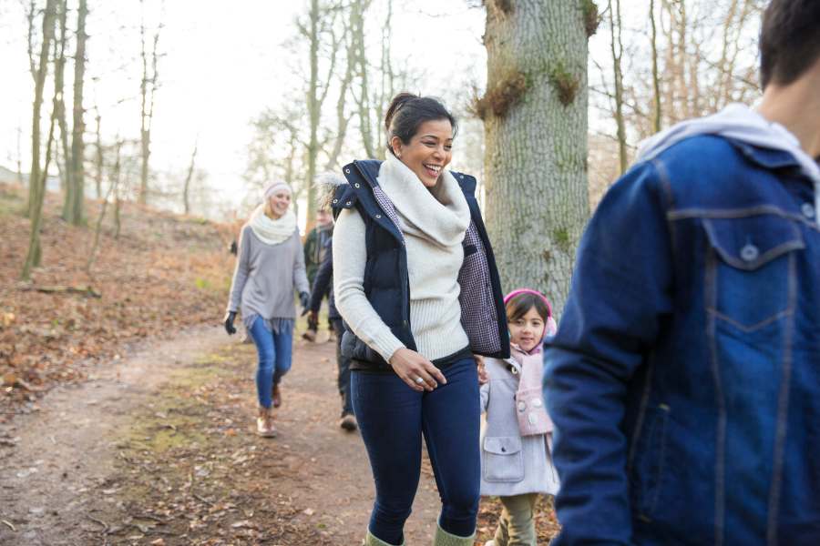 A small group of people hiking on a trail surrounded by trees.