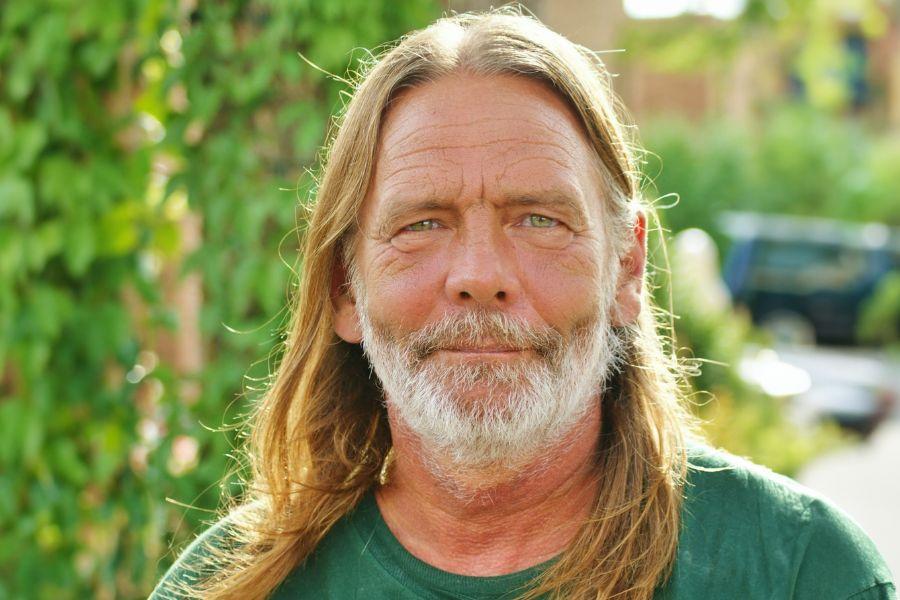 Headshot of Bruce Lohmiller in front of green leaves. 