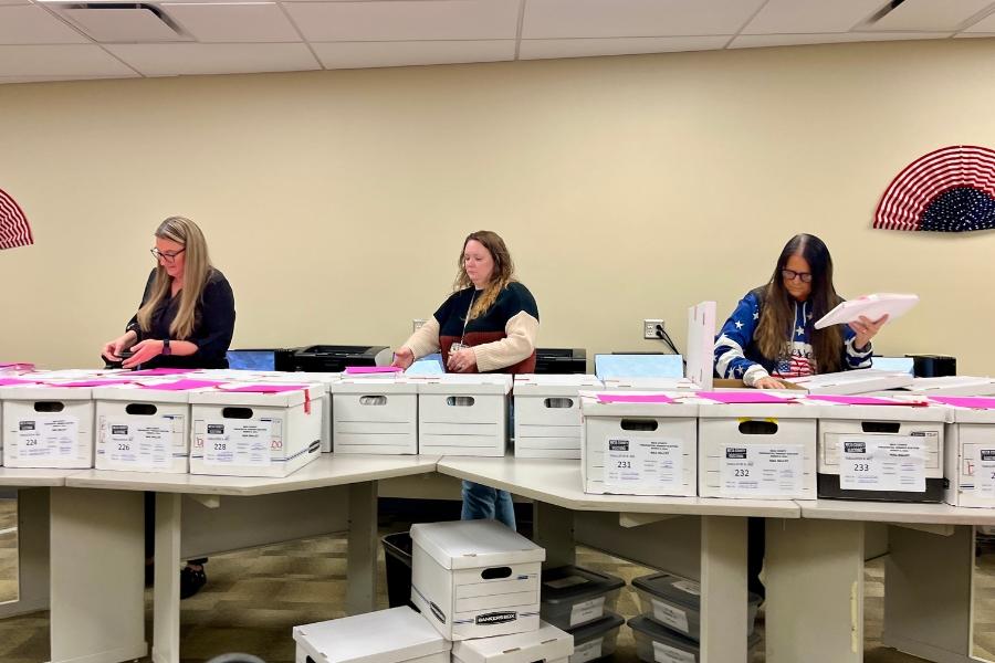 3 people reviewing ballots. 