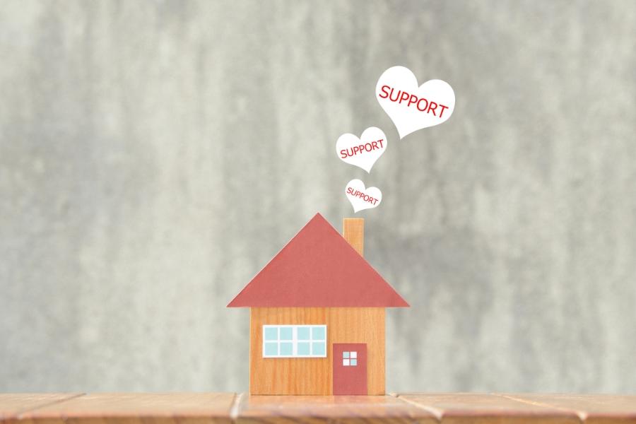 Red and brown paper house with white hearts coming out of the chimney with red text reading, "support."