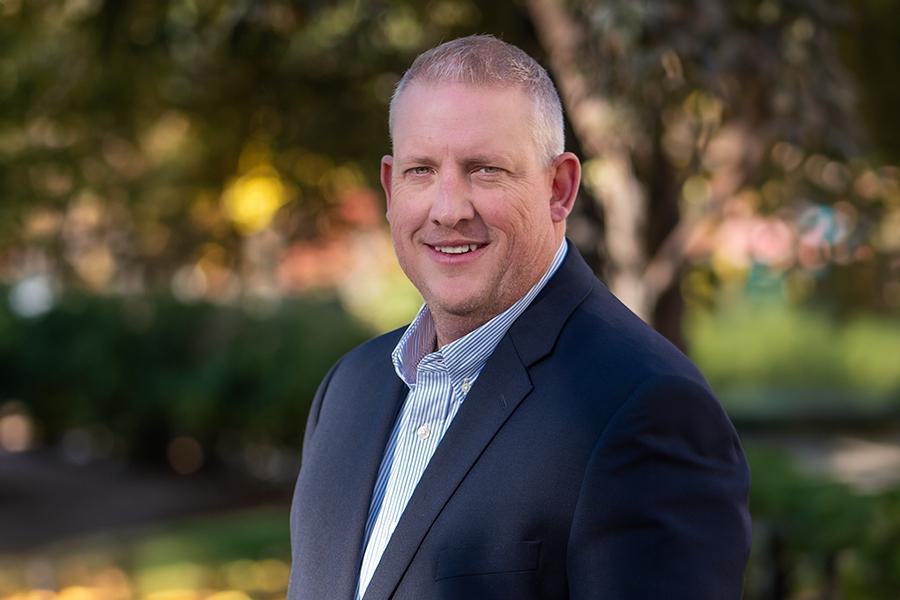 Man (Todd Hollenbeck) smiling at camera for headshot.